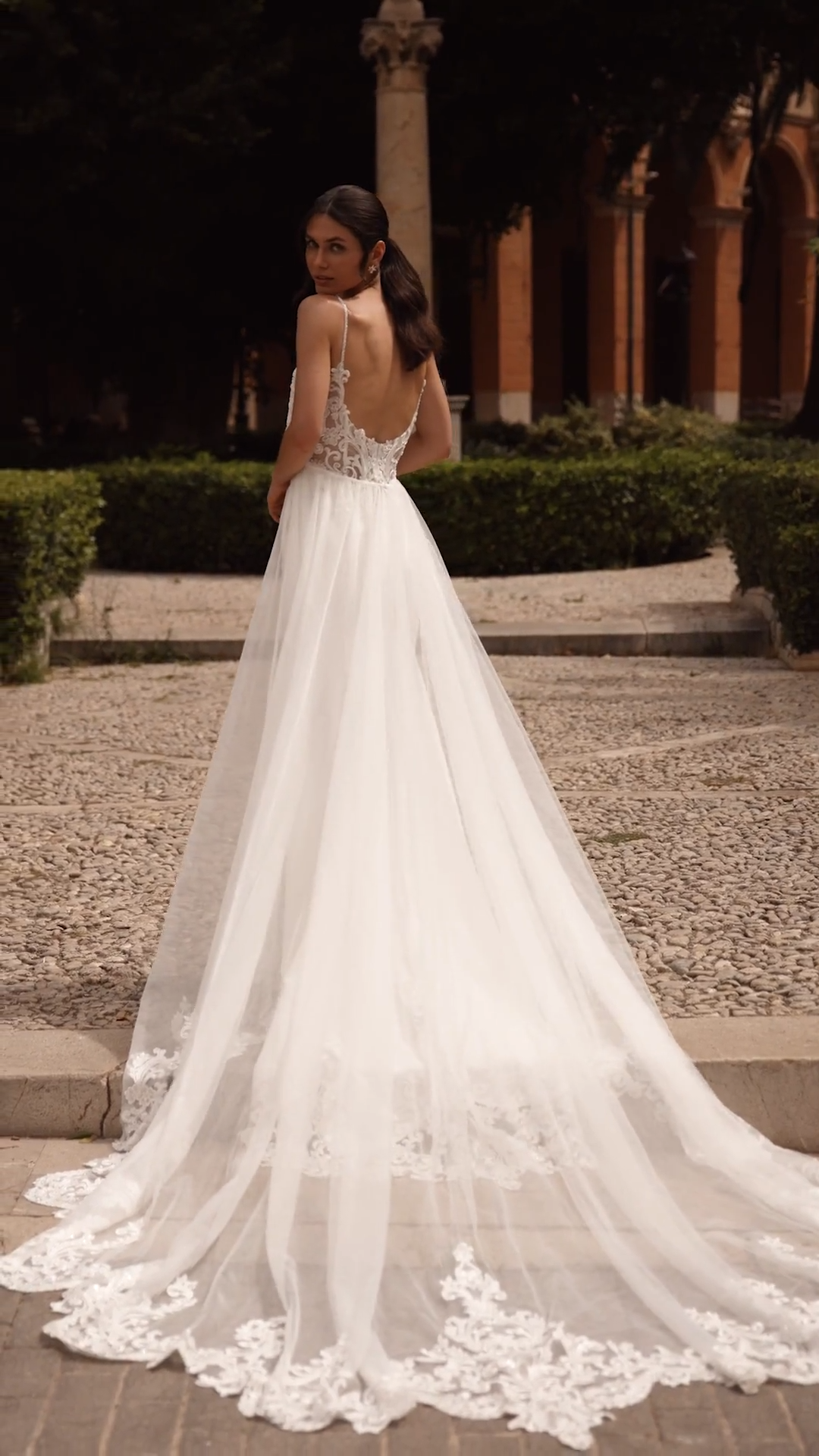 Bride wearing an ivory crepe convertible wedding dress with detachable tulle overskirt Bride wearing an ivory crepe convertible wedding dress with detachable tulle overskirt