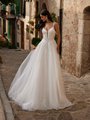 Bride wearing lightweight tulle wedding dress with deep sweetheart neckline and spaghetti straps Bride wearing lightweight tulle wedding dress with deep sweetheart neckline and spaghetti straps