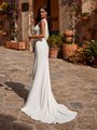 Back view of bride in ivory crepe wedding dress with low v-shaped back with chiffon detailing Back view of bride in ivory crepe wedding dress with low v-shaped back with chiffon detailing